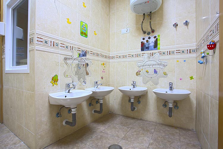 Baños de la escuela infantil Educamar con cuatro lavabos.